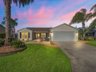 Single-story home with white siding, attached garage, and landscaped yard at 2338 Mcclellanville Ter, The Villages, FL 32162