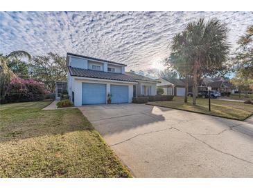 Two-story house with light blue garage doors and a landscaped lawn at 2355 Lakeview Ave, Clermont, FL 34711