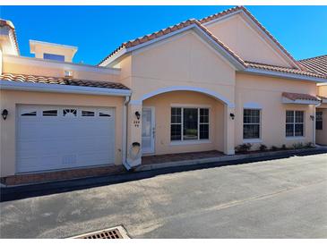 Front view of charming condo with attached garage and attractive landscaping at 255 David Walker Dr # F5, Tavares, FL 32778