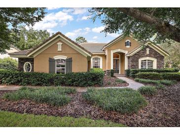 Beautiful two-story home with stone accents and lush landscaping at 25833 Feather Ridge Ln, Sorrento, FL 32776