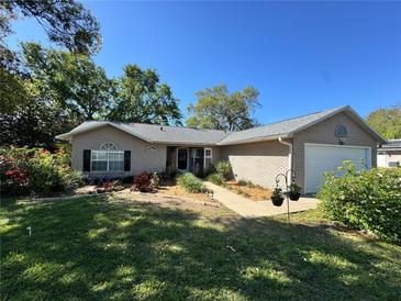 Charming single-story brick home with well-maintained landscaping and a cozy, inviting curb appeal at 36703 Sandy Ln, Grand Island, FL 32735