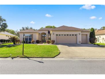 Single-story home with attached garage and manicured lawn at 9565 Se 124Th Loop, Summerfield, FL 34491