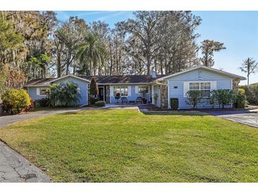 Charming ranch home with lakefront views, mature landscaping, and a spacious yard at 9724 Rosemary Ln, Leesburg, FL 34788