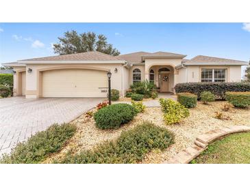 Single-story home with landscaped yard, attached garage, and brick paved driveway at 1870 Saybrook Way, The Villages, FL 32162