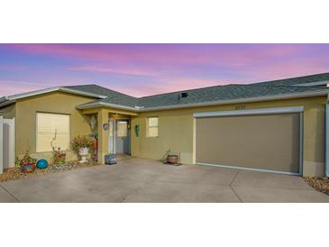 Well-maintained house with a two-car garage and landscaped front yard at 2057 Countrywind Ct, The Villages, FL 32162