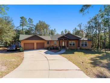 Single-story home with two-car garage and a spacious driveway at 2187 County Road 243C, Wildwood, FL 34785