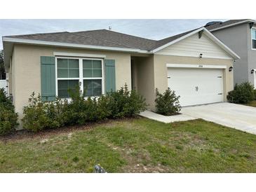 Single-story house with a two-car garage and landscaping at 29320 Armoyan Blvd, Leesburg, FL 34748