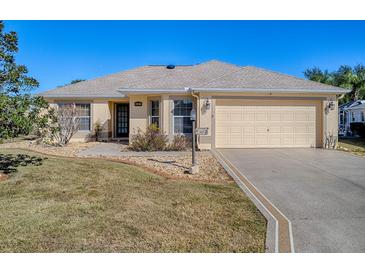 Cute single-story home with a two-car garage and well-manicured lawn at 307 Batesburg Way, The Villages, FL 32162