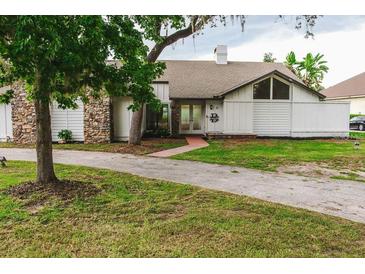 White home with stone accents and a large grassy yard at 31 Sand Lake Pl, Eustis, FL 32726