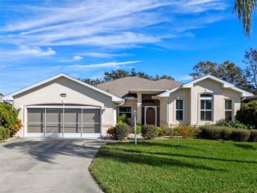 Single-story home with a two-car garage and well-maintained landscaping at 6319 Berkshire Pass, Leesburg, FL 34748