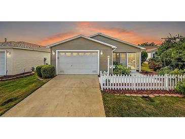 Inviting exterior featuring a white picket fence and a two-car garage at 1280 Mount Vernon Way, The Villages, FL 32162