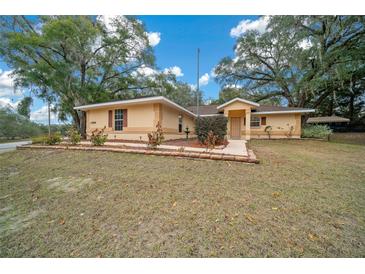 Charming single-story home with a well-manicured lawn and lovely landscaping at 13588 Sw 105Th Pl, Dunnellon, FL 34432