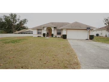 Single-story house with a two-car garage and a basketball hoop at 137 Country Lakes Cir, Groveland, FL 34736