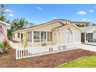 Cute ranch home with a white picket fence and well-manicured landscaping at 1526 Lozano Ave, Lady Lake, FL 32159