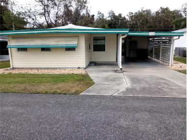 Front view of a single story home with carport at 164 Jacaranda Dr, Leesburg, FL 34748