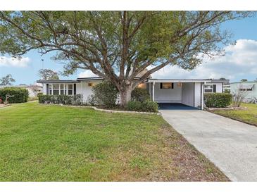 Single-story home with carport, mature landscaping, and large tree in front at 2753 Vindale Rd, Tavares, FL 32778