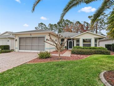 Single-story home with screened porch and landscaped yard at 353 Ranchwood Dr, Leesburg, FL 34748