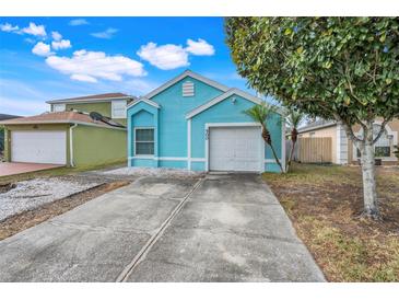 Cute teal house with a two-car garage and a small front yard at 500 Southern Charm Dr, Orlando, FL 32807