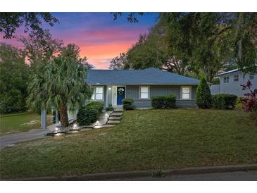 Charming house with a gray exterior, landscaping, and a walkway leading to the entrance at 1660 1St St, Clermont, FL 34711