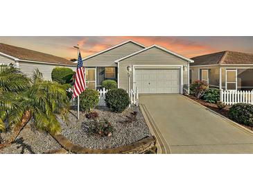 Exterior of charming single story home with landscaped yard, driveway, and American flag at 3347 Empire Ave, The Villages, FL 32163