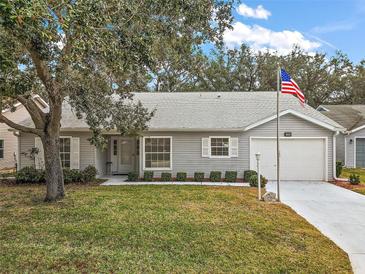 Gray house with a white garage door and landscaped lawn at 5505 Tangelo St, Leesburg, FL 34748