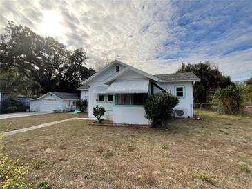 Charming white house with green accents, detached garage, and spacious yard at 13920 S Highway 25, Eastlake Weir, FL 32133