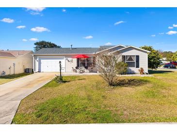 Single story home with attached garage and landscaped yard at 1842 Captiva Ct, The Villages, FL 32162