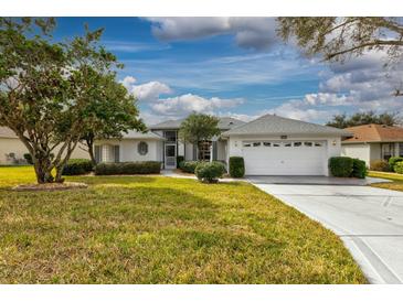 Single-story home with attached garage and well-manicured lawn at 26908 Honeymoon Ave, Leesburg, FL 34748