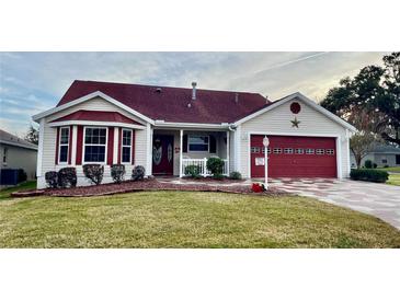 One-story home with red roof, red garage door, and landscaped lawn at 2762 Morven Park Way, The Villages, FL 32162