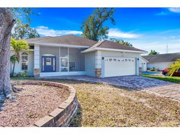 House exterior boasts a modern design, paver driveway, and screened porch at 415 Renee Dr, Haines City, FL 33844