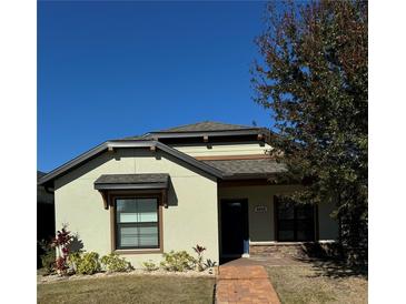 Charming single-story home with a well-manicured lawn and brick walkway leading to the front door at 4556 Water Oak Ter, Oxford, FL 34484