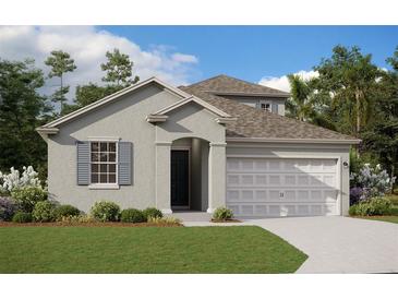 Two-story house with grey siding, two-car garage, and landscaped lawn at 5119 Firebush Dr, Apopka, FL 32712