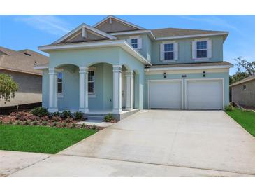 Charming two-story home features a two-car garage and landscaped front yard, creating appealing curb appeal at 5155 Firebush Dr, Apopka, FL 32712
