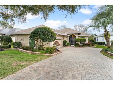 Single story home with paver driveway and manicured landscaping at 6216 Landings Blvd, Lady Lake, FL 32159