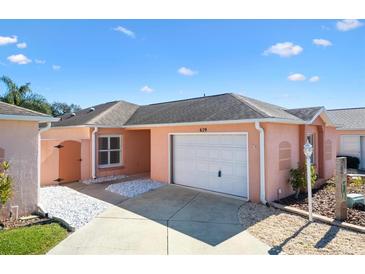 Charming single-story home with a one-car garage and well-maintained landscaping on a sunny day at 629 Nuevo Leon Ln, The Villages, FL 32159