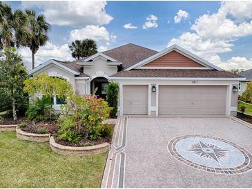 Two-story house with a three-car garage and landscaped front yard at 5911 Delphina Loop, The Villages, FL 32163