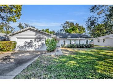 Single-story house with a two-car garage and a well-maintained lawn at 1101 Lantana Dr, Eustis, FL 32726