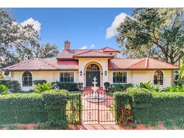 House exterior featuring a red tile roof, arched entryway, and fountain at 1130 Elysium Blvd, Mount Dora, FL 32757