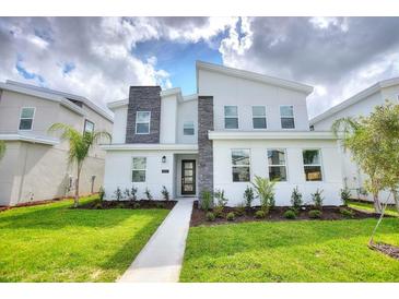 Modern two-story home with stone accents and landscaped lawn at 1257 Challenge Dr, Davenport, FL 33896