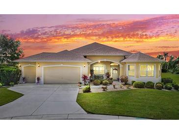 Charming single-Gathering home boasts a spacious three-car garage, meticulously landscaped yard, and a welcoming facade at sunset at 1276 Bennett Pl, The Villages, FL 32162