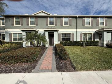 Two-story townhome with a landscaped front yard and brick walkway at 16929 Tesla Aly, Winter Garden, FL 34787