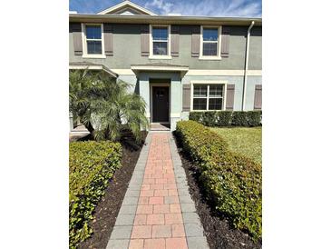 Charming two-story townhome with a brick walkway and lush landscaping at 16929 Tesla Aly, Winter Garden, FL 34787