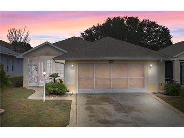 One-story house with a two-car garage and screened porch at 21122 Lionheart Dr, Leesburg, FL 34748