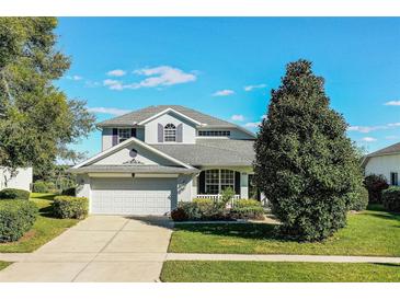 Two-story house with a gray roof, white garage door, and lush landscaping at 3898 Beacon Ridge Way, Clermont, FL 34711