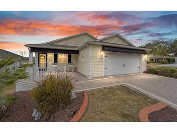 House exterior featuring a 2-car garage and landscaped front yard at 392 Arbella Loop, The Villages, FL 32162