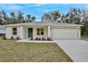 Newly constructed home with a two-car garage and well-manicured lawn at 40210 Orange Cir, Lady Lake, FL 32159