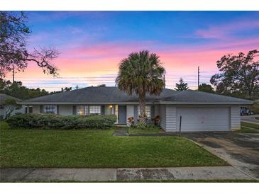 White single-story house with a palm tree and attached garage at 5938 Marlberry Dr, Orlando, FL 32819