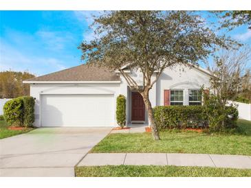 White house with brown door, two-car garage, and landscaping at 742 Franklin Ct, Haines City, FL 33844