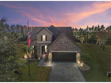 Two-story home with stone accents and a three-car garage at 9277 Sw 70Th Loop, Ocala, FL 34481