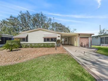 Single story home with carport and landscaped yard at 1303 E Schwartz Blvd, The Villages, FL 32159